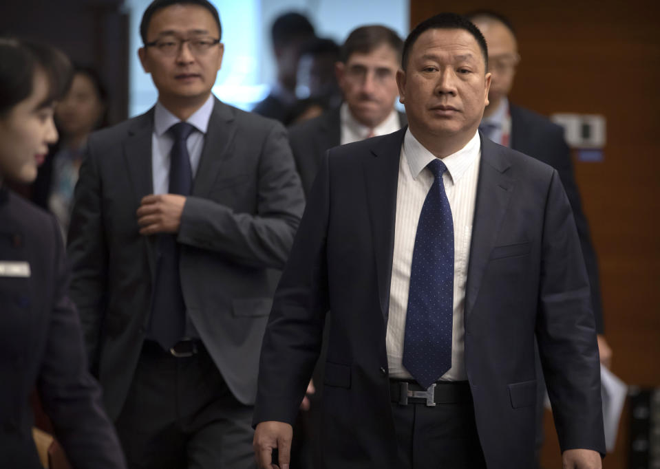 Song Liuping, right, chief legal officer of Huawei, arrives for a press conference at Huawei's campus in Shenzhen in southern China's Guandong Province, Thursday, Dec. 5, 2019. Chinese tech giant Huawei is asking a U.S. federal court to throw out a rule that bars rural phone carriers from using government money to purchase its equipment on security grounds. (AP Photo/Mark Schiefelbein)