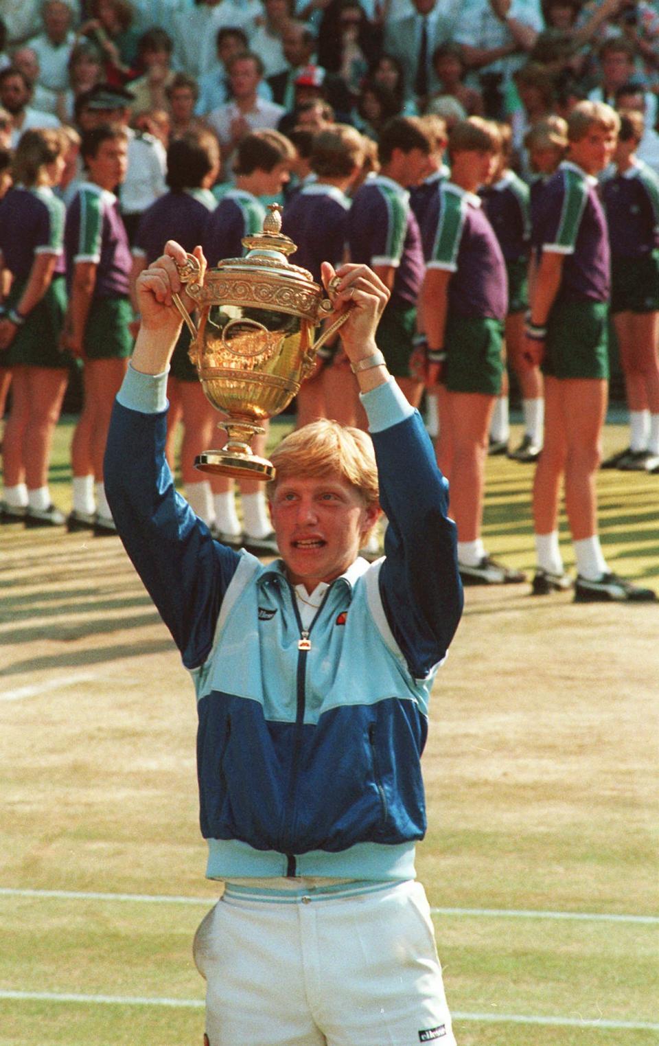 FILE - In this July 7, 1985, file photo, 17-year-old Boris Becker holds the Wimbledon trophy aloft after defeating South Africa's Kevin Curren. (AP Photo/Bob Dear, File)