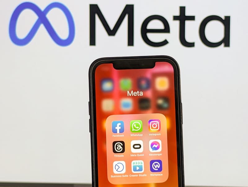 Mobile apps are seen on an iPhone screen in front of the logo of Meta. Christoph Dernbach/dpa