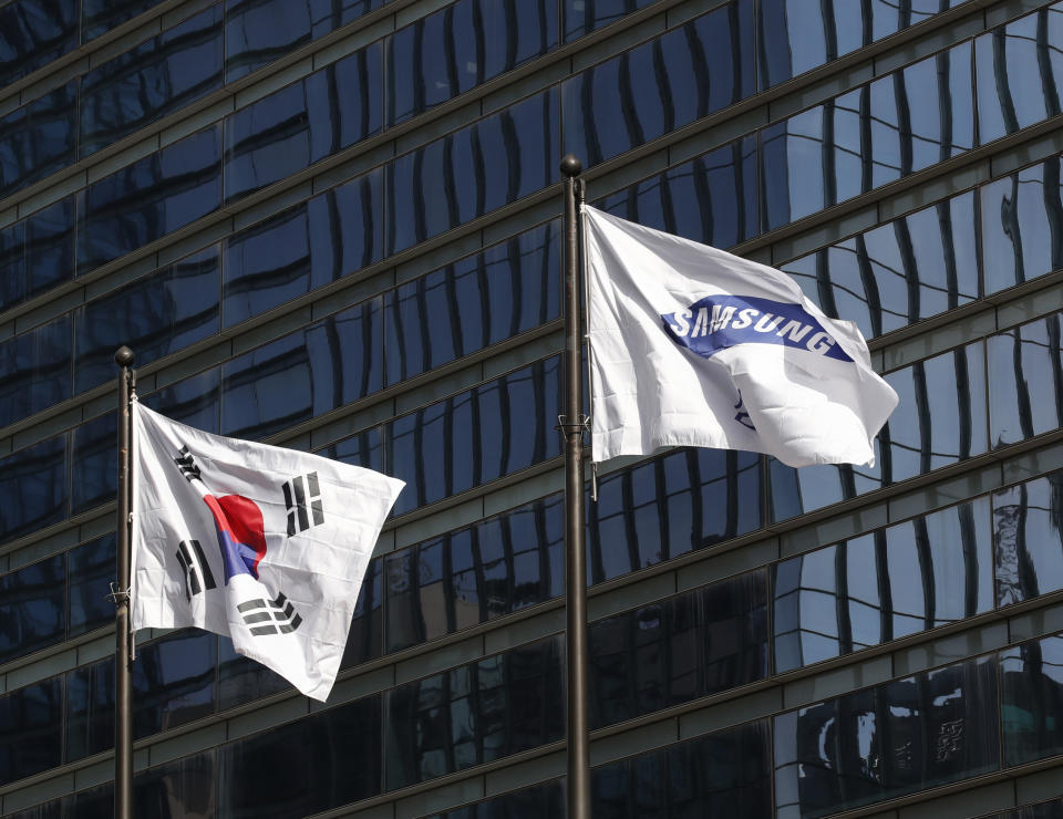 A flag of Samsung flutters next to the South Korean national flag outside of Samsung's Seocho office building in Seoul, South Korea, Sunday, Oct. 25, 2020. Lee Kun-Hee, the ailing Samsung Electronics chairman who transformed the small television maker into a global giant of consumer electronics, has died, a Samsung statement said Sunday. He was 78. (AP Photo/Lee Jin-man)