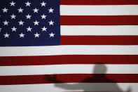 Democratic presidential candidate former Vice President Joe Biden casts a shadow on a flag as he speaks during a community event, Wednesday, Oct. 16, 2019, in Davenport, Iowa. (AP Photo/Charlie Neibergall)