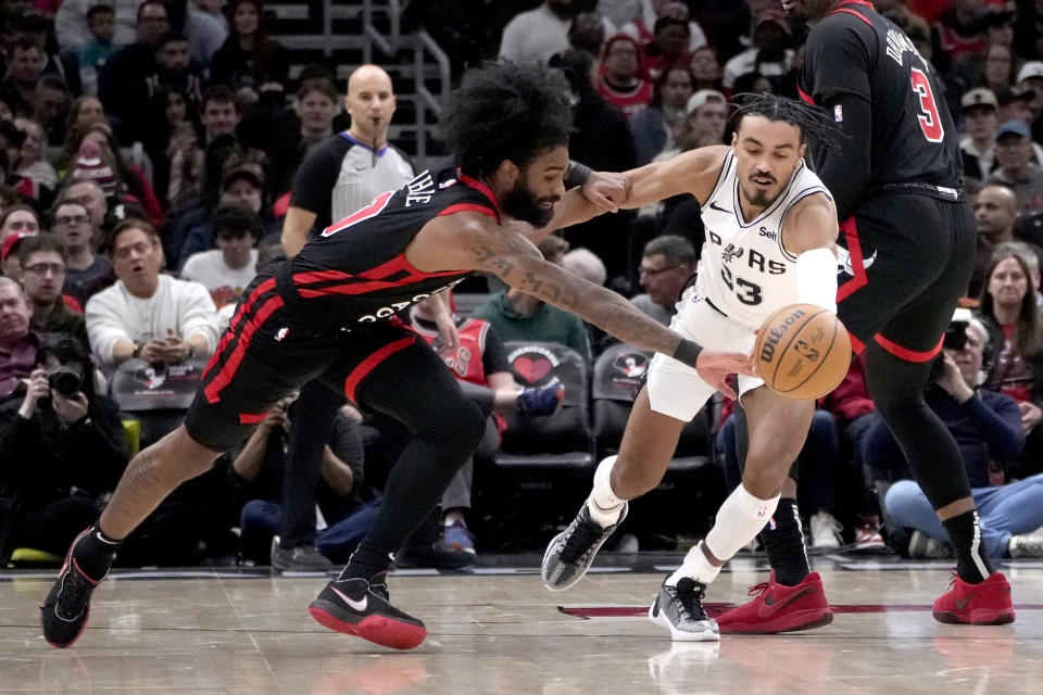 San Antonio Spurs' Tre Jones (33) steals the ball from Chicago Bulls' Coby White, left, during the first half of an NBA basketball game Thursday, Dec. 21, 2023, in Chicago. (AP Photo/Charles Rex Arbogast)