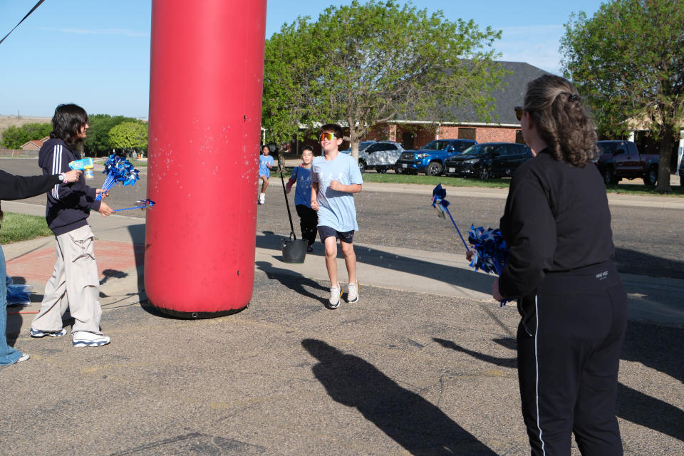A couple of young bots finish the "Walk a Mile in Their Shoes,” a one-mile run/walk event at The Bridge Children's Advocacy Center in Amarillo on Saturday.