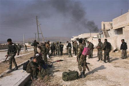 Forces loyal to Syria's President Bashar al-Assad carry their weapons as they gather in the town of Safira November 1, 2013. REUTERS/George Ourfalian