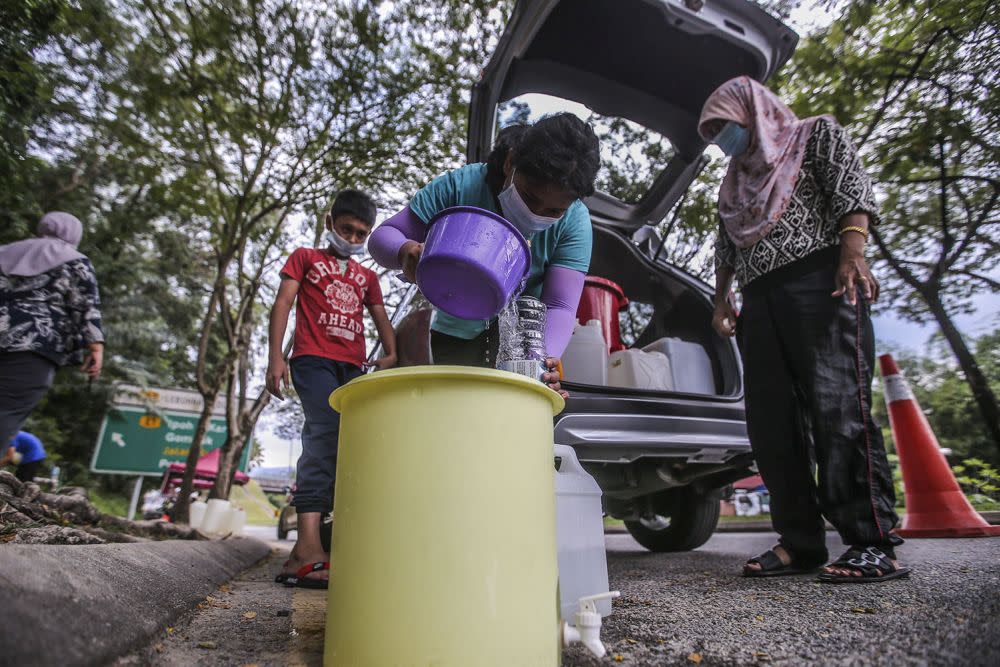 Residents fill their pails at a water point in Keramat AU2 following the latest water disruption October 20, 2020. — Picture by Hari Anggara