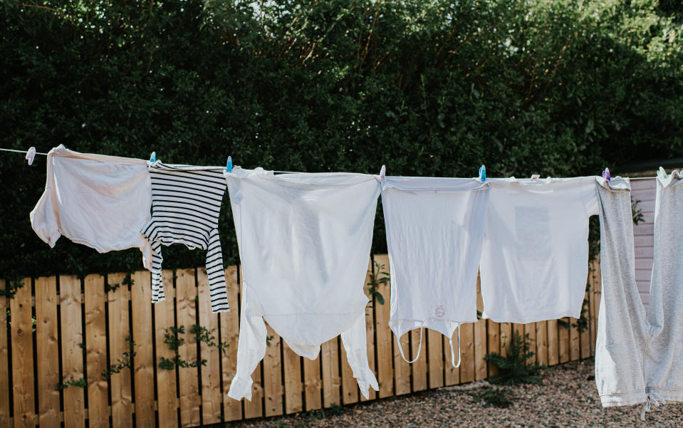 Laundry is hung up on an outside washing line to dry on a sunny day. 