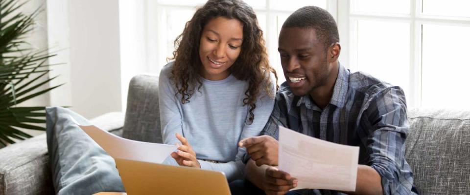 Couple sitting on sofa reviewing mortgage rates