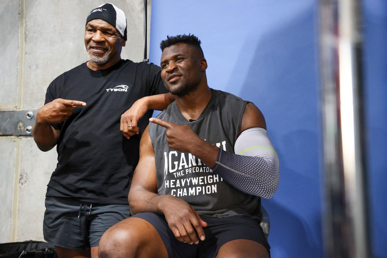 Former US boxer Mike Tyson (L) and Francis Ngannou pose for a photo after a training session at Ngannou's gym in Las Vegas, Nevada, on  September 26, 2023. Mixed martial arts star Francis Ngannou will have heavyweight legend Mike Tyson in his corner when he faces World Boxing Council heavyweight champion Tyson Fury in the boxing ring in Saudi Arabia on October 28. (Photo by Ian Maule / AFP) (Photo by IAN MAULE/AFP via Getty Images)