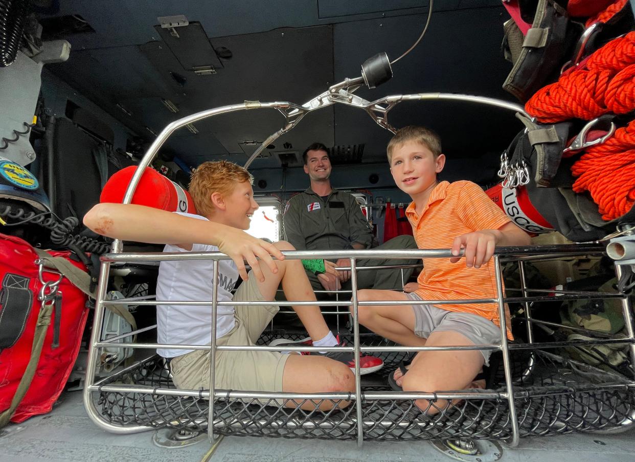 Ready to be rescued as Michael Trubkin, 10, and Reid Weibley,7, trying out the rescue basket as United States Coast Guard's aircrew member Stephen Bedwell explains some of the procedures during a basket rescue.