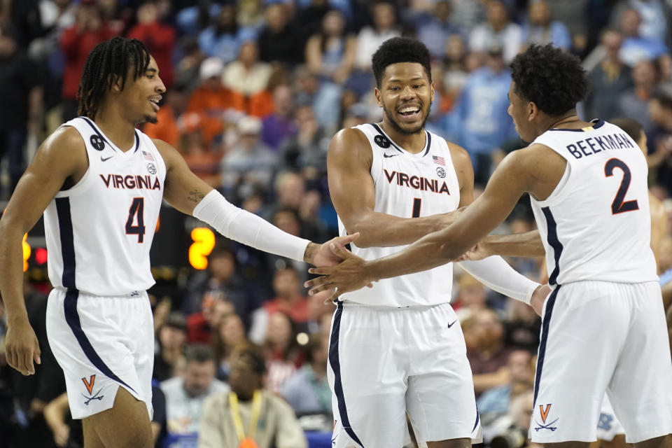 Virginia players, from left to right, Armaan Franklin, Jayden Gardner and Reece Beekman celebrate during the second half of an NCAA college basketball game against North Carolina at the Atlantic Coast Conference Tournament in Greensboro, N.C., Thursday, March 9, 2023. (AP Photo/Chuck Burton)