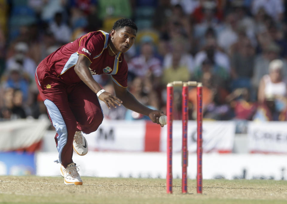 West Indies' Krishmar Santokie prepares to throw the ball at the stumps to dismiss England's Moeen Ali during their third T20 International cricket match at the Kensington Oval in Bridgetown, Barbados, Thursday, March 13, 2014. (AP Photo/Ricardo Mazalan)