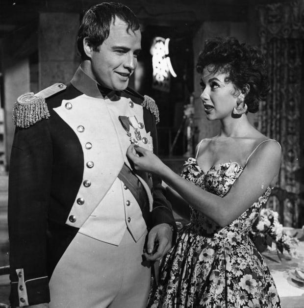 Marlon Brando and Rita Moreno visit on the set of the film "Desiree" in 1954.<p><a href="https://www.gettyimages.com/detail/136163099" rel="nofollow noopener" target="_blank" data-ylk="slk:Archive Photos/Getty Images;elm:context_link;itc:0;sec:content-canvas" class="link ">Archive Photos/Getty Images</a></p>