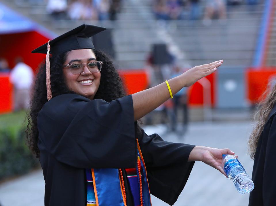 A University of Florida graduate does the Gators Chomp as she makes her way into the Spring 2022 Commencement Ceremony being held at Ben Hill Griffin Stadium, in Gainesville Fla. April 29, 2022. Florida Gators great Tim Tebow was the commencement speaker. He talked about not just being successful, but being sure that you were being significant.  [Brad McClenny/The Gainesville Sun]   