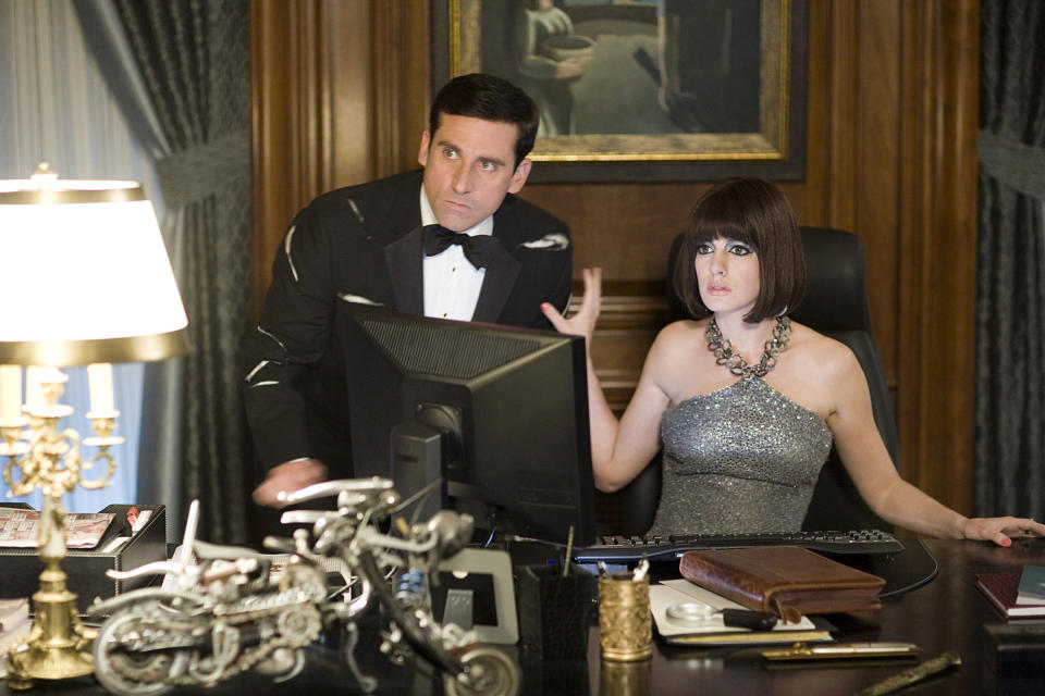 Steve Carell and Anne Hathaway dressed up while on the computer looking startled and serious