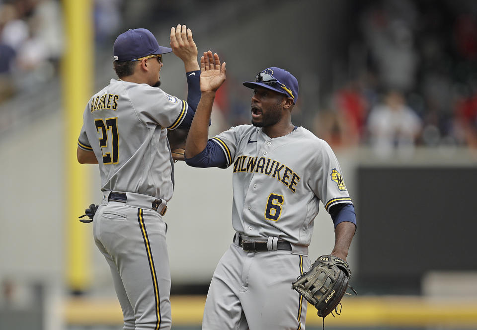 Milwaukee Brewers' Willy Adames, left, celebrates with Lorenzo Cain (6) at the end of a baseball game against the Atlanta Braves, Sunday, Aug. 1, 2021, in Atlanta. (AP Photo/Ben Margot)