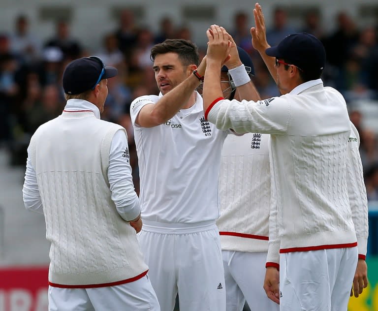 England's James Anderson (C) celebrates with captain Alastair Cook after taking the wicket of Sri Lanka's Dimuth Karunaratne (L) on the third day of the first Test at Headingley on May 21, 2016