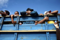 Honduran migrants, part of a caravan trying to reach the U.S., are pictured inside a truck during a new leg of their travel, in Guatemala City, Guatemala October 18, 2018. REUTERS/Edgard Garrido