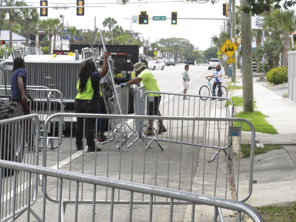 A worker places a section of metal barricade along a main road on Tybee Island, Ga., on Tuesday, April 16, 2024, a few days ahead of the weekend beach party known as Orange Crush. Black college students started the spring bash at Georgia's largest public beach more than 30 years ago. Tybee Island officials are blocking roads and parking spaces and brining in about 100 extra police officers for the party this weekend, saying record crowds last year proved unruly and dangerous. (AP Photo/Russ Bynum)