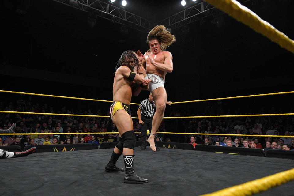 Matt Riddle, right, puts a knee in the face of Undisputed Era's Adam Cole on 