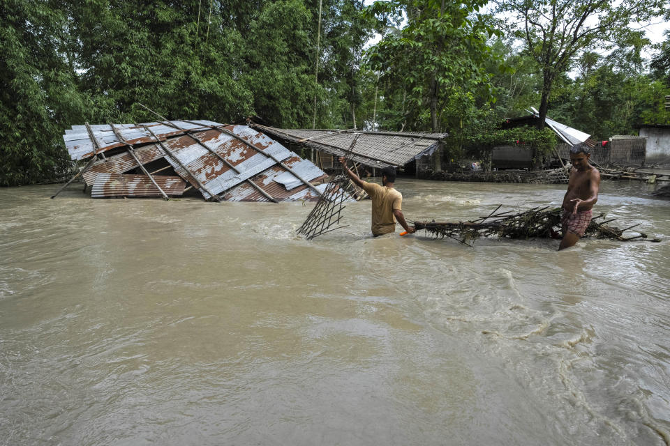 Villagers salvage belongings from their flood-damaged houses in Bali village, west of Guwahati, India, Friday, June 23, 2023. Tens of thousands of people have moved to relief camps with one person swept to death by flood waters caused by heavy monsoon rains battering swathes of villages in India’s remote northeast this week, a government relief agency said on Friday. (AP Photo/Anupam Nath)