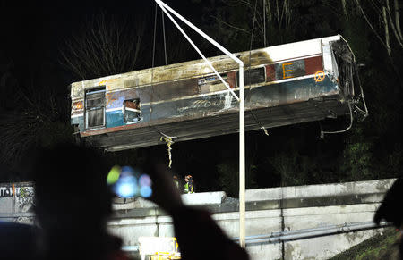 A damaged Amtrak passenger train car is lifted from the tracks at the site of the derailment of Amtrak train 501 in Dupont, Washington, U.S., December 19, 2017. REUTERS/Thomas James