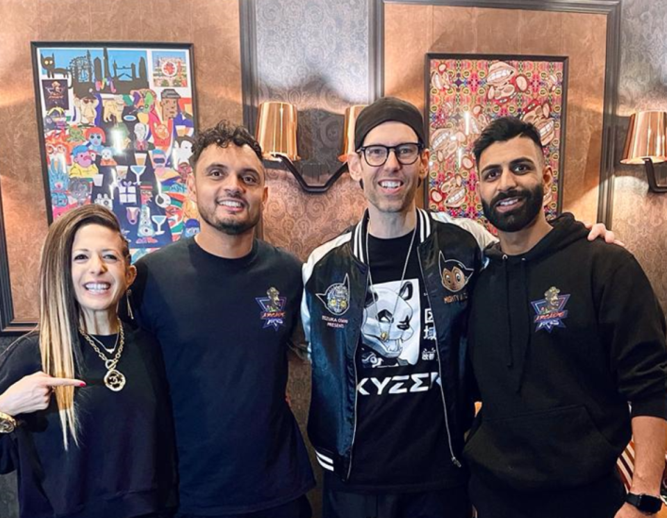 Co-founder and host of Impact Theory Tom Bilyeu with his wife Lisa and co-founders of Arcade Apes Vishaal Hindocha and Samit Max Patel.
