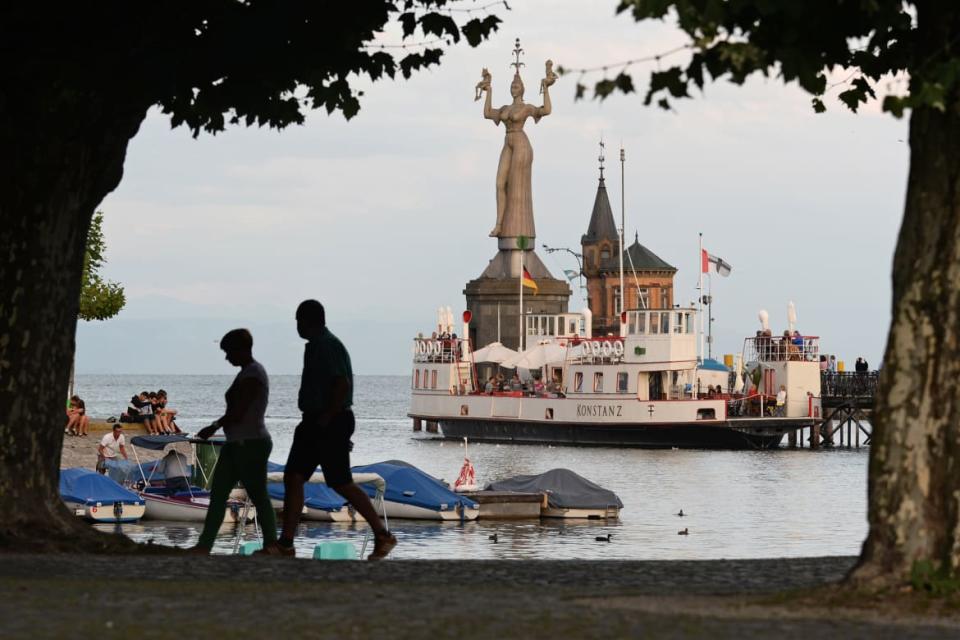 <div class="inline-image__title">1040778914</div> <div class="inline-image__caption"><p>Two people walk along the harbor promenade in front of the so-called "Imperia," a statue at the entrance to the harbour, shortly before sunset in Konstanz, Germany, 13 August 2013.</p></div> <div class="inline-image__credit">Getty</div>