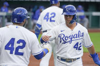 Kansas City Royals' Whit Merrifield, right, celebrates with Carlos Santana after he scored on a double by Andrew Benintendi during the first inning of a baseball game against the Toronto Blue Jays Thursday, April 15, 2021, in Kansas City, Mo. (AP Photo/Charlie Riedel)