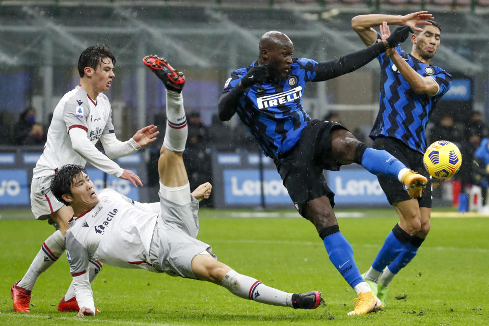 FILE - In this Dec. 5, 2020, file photo, Bologna's Takehiro Tomiyasu, left, and Inter Milan's Romelu Lukaku fight for the ball during a Series A soccer match between Inter Milan and Bologna, at Milan's San Siro Stadium. The photo was honored by the Associated Press Sports Editors as best sports action photo of 2020 at their annual winter meeting. (AP Photo/Antonio Calanni, File)