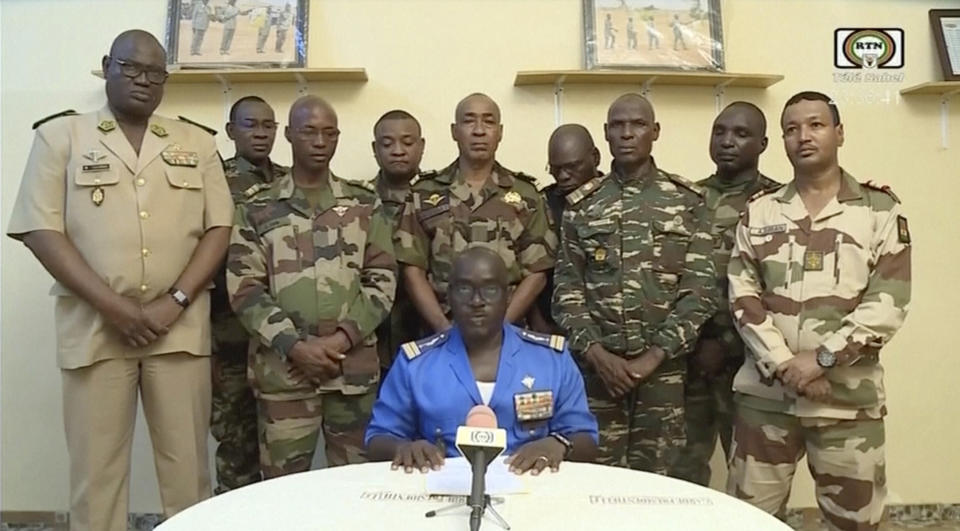 Col. Maj. Amadou Abdramane, with a delegation of military officers standing behind him, makes a televised statement.