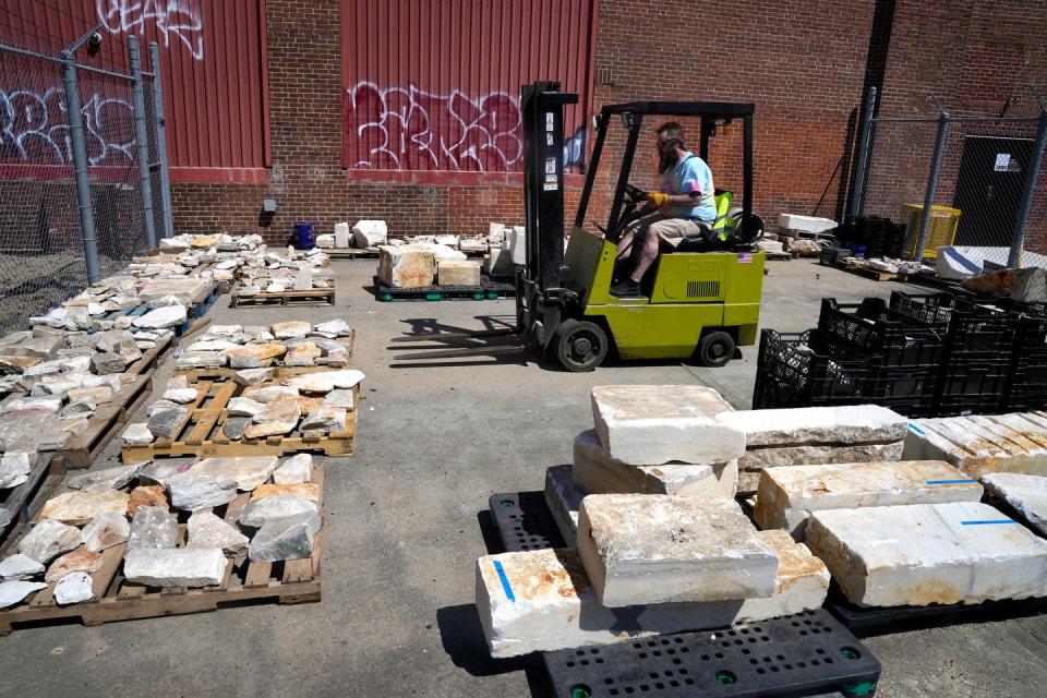 Dan Neff, co-head distiller at Industrial Spirits, volunteers for Farm Fresh RI's marble sale by moving pieces of the rock from storage to sale site.