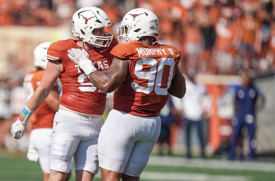 Texas defensive end Ethan Burke, left, and defensive lineman Bryon Murphy II celebrate a sack during the Rice game.