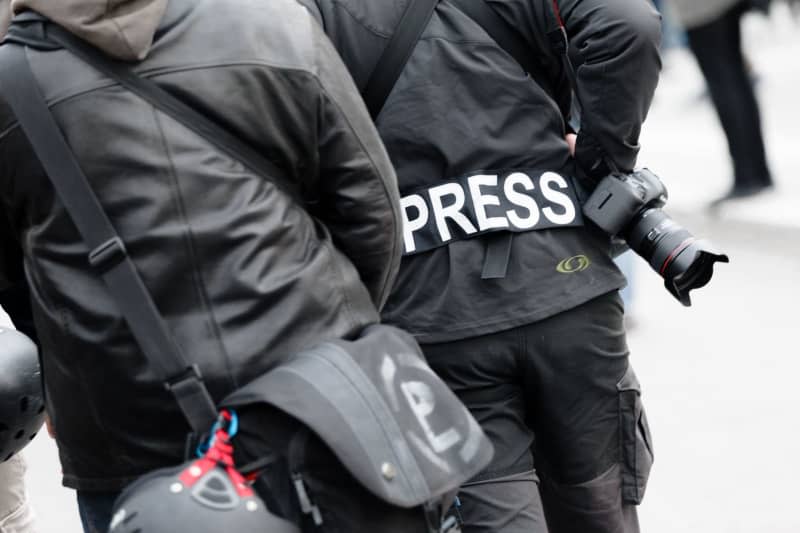 A photojournalist wears a patch with the text "Press" on his jacket at a demonstration to identify himself as a journalist to police and demonstrators. There were more attacks on journalists in Germany in 2023 than in the previous year, the European Centre for Press and Media Freedom (ECPMF) has found. Markus Scholz/dpa