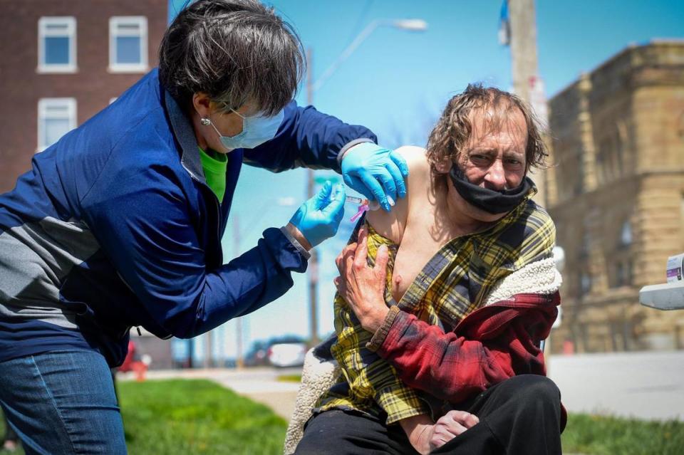 Glenda Mauer, a medical doctor from Norton, Kansas, gave a COVID-19 vaccination to David Coates, 50, at a clinic staffed by Care Beyond The Boulevard on Tuesday, April 13, outside of ReStart, a shelter for the homeless in Kansas City. The volunteers were working with vaccines made available from Moffet Drug in Norton, Kansas and Ward Drug in Oberlin, Kansas. Thanks to a collaboration with the two pharmacies, and the Jackson County Health Department, Care Beyond the Boulevard will be able to provide more than 1,000 vaccinations to patients beginning Monday. “I came to Kansas City to give more vaccines to more people to protect the nation and to help the homeless,” said Mauer. “It overwhelms me, with every shot I get teary-eyed,” she said. “I’m excited to be here.” Mauer was one of three volunteers who traveled from Norton, Kansas to volunteer to help with the COVID-19 vaccinations.