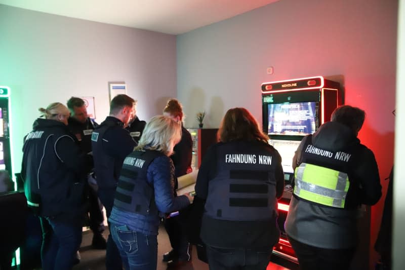 Employees Of The Nrw Tax Investigation Department Stand By Gambling Machines During A Search Of A Gambling Hall. Police, Customs, The Public Order Office And The Tax Investigation Department Jointly Searched Premises In Duisburg Under Suspicion Of Illegal Gambling Under The Watchful Eye Of Nrw Interior Minister Reul. -/Dpa