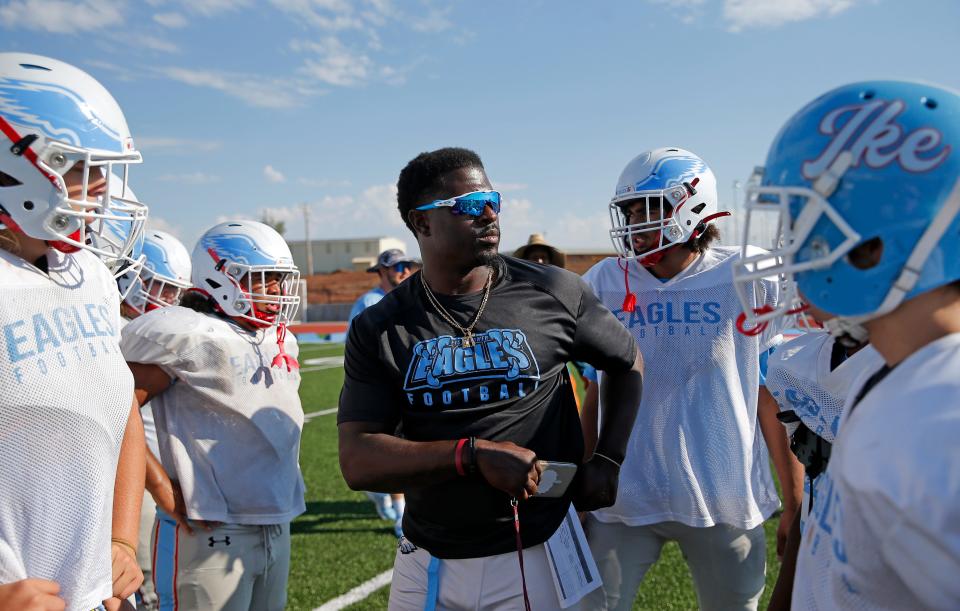 Lawton Eisenhower football coach Javon Harris, center, talks with this team during practice on Tuesday. Harris, a former Lawton MacArthur star and OU safety, is in his second year guiding the Eagles while trying to establish a new culture.