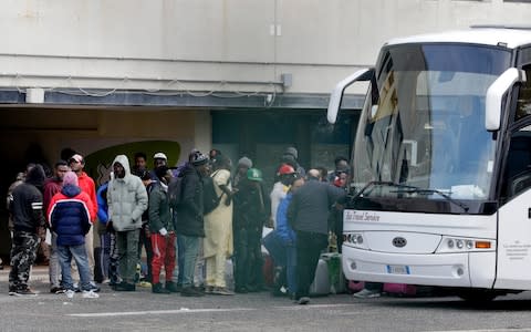 Migrants wait to board a bus to leave the Castelnuovo di Porto reception centre - Credit: Andrew Medichini/AP