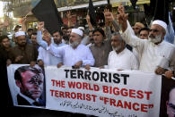 Pakistan traders hold a banner with a defaced picture of French President Emmanuel Macron during a protest against the publishing of caricatures of the Prophet Muhammad they deem blasphemous, in Peshawar, Pakistan, Monday, Oct. 26, 2020. Pakistan's Prime Minister Imran Khan said the French leader chose to encourage anti-Muslim sentiment and deliberately provoke Muslims by encouraging the display of blasphemous cartoons targeting Islam. (AP Photo/Muhammad Sajjad)