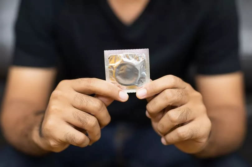 Close up Male hand holding Condom. Safe sex concept.