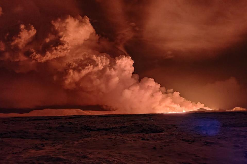 El humo se eleva mientras la lava tiñe el cielo nocturno de naranja debido a una erupción volcánica en la península de Reykjanes, a 3 km al norte de Grindavik, al oeste de Islandia, el 18 de diciembre de 2023.