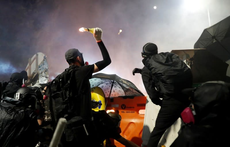 Protesters throw a molotov cocktail during a standoff with riot police at the Chinese University of Hong Kong