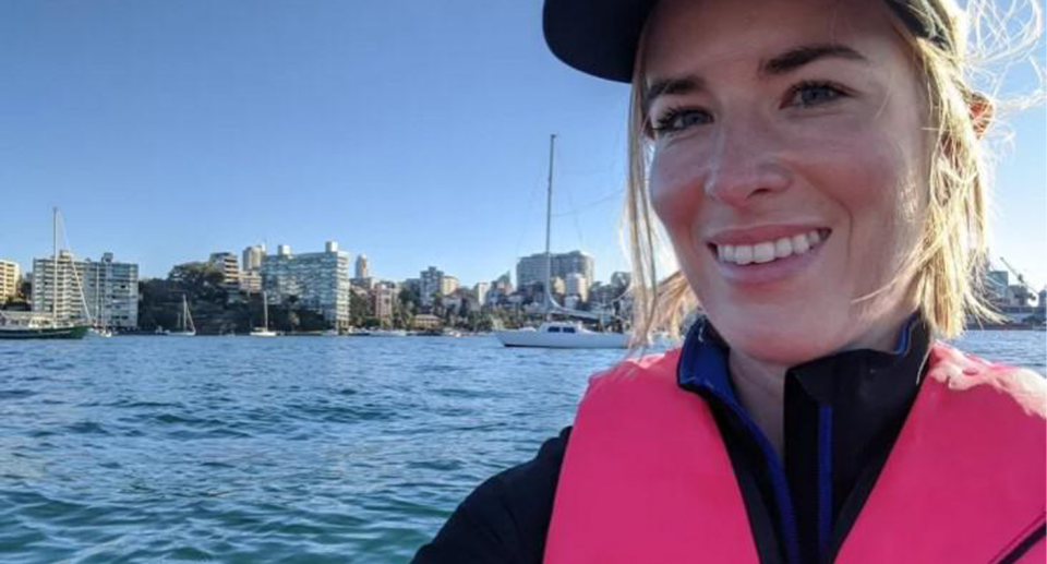 Lauren O'Neill, 29, takes a selfie in front of Potts Point at the water.