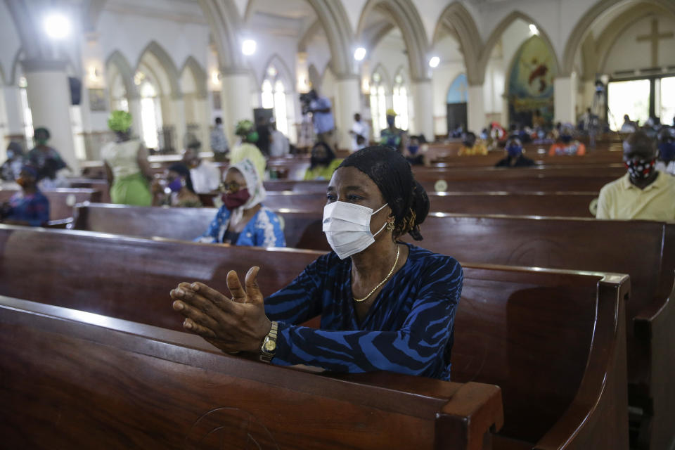 A churchgoer wears a face mask and practises social-distancing to curb the spread of the coronavirus during a Sunday mass at the Holy Cross Cathedral in Lagos, Nigeria Sunday, Aug. 30, 2020. The COVID-19 pandemic is testing the patience of some religious leaders across Africa who worry they will lose followers, and funding, as restrictions on gatherings continue. (AP Photo/Sunday Alamba)