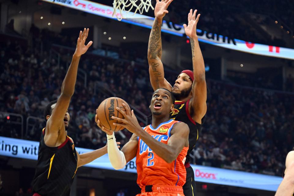 CLEVELAND, OHIO - JANUARY 22: Evan Mobley #4 and Lamar Stevens #8 of the Cleveland Cavaliers try to block Shai Gilgeous-Alexander #2 of the Oklahoma City Thunder during the first quarter at Rocket Mortgage Fieldhouse on January 22, 2022 in Cleveland, Ohio.