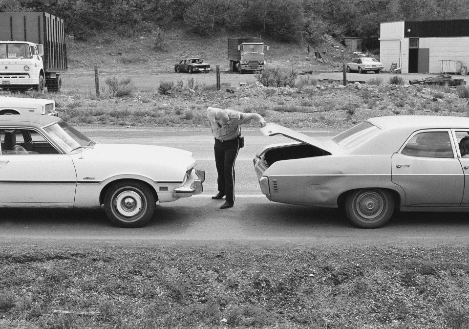 FILE - In this June 1977 file photo, police officers inspect a vehicles at a roadblock near Glenwood Springs, Colo. Suspected serial killer Ted Bundy escaped from the Pitkin County Courthouse on June 7, 1977. (Ross Dolan/Glenwood Springs Post-Independent via AP)