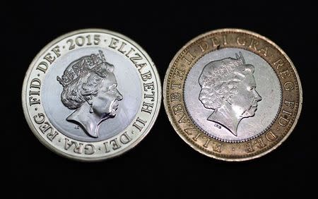 The new portrait of Britain's Queen Elizabeth on a 2-pound coin (L) is seen next to the previous portrait at the National Portrait Gallery in London March 2, 2015. REUTERS/Suzanne Plunkett