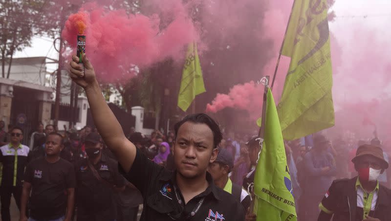 Protesters light flares during a rally against alleged fraud in the Feb. 14 presidential election, outside the General Election Commission’s office in Jakarta, Indonesia, Wednesday, Feb. 21, 2024. According to “quick counts” from selected polling stations, the winner of the presidential contest is Prabowo Subianto.