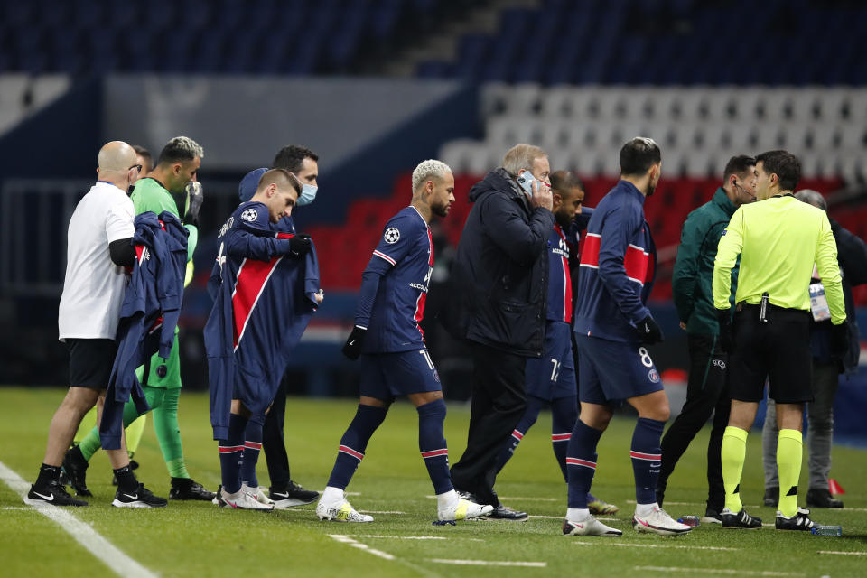 Los jugadores de Paris Saint Germain abandonan el terreno de juego en protesta por una expresión racista usada por el cuarto árbitro para aludir al ayudante del técnico del equipo turco Basaksehir durante un encuentro de la Liga de Campeones en el estadio Parc des Princes de París, el 8 de diciembre de 2020. (AP Foto/Francois Mori)