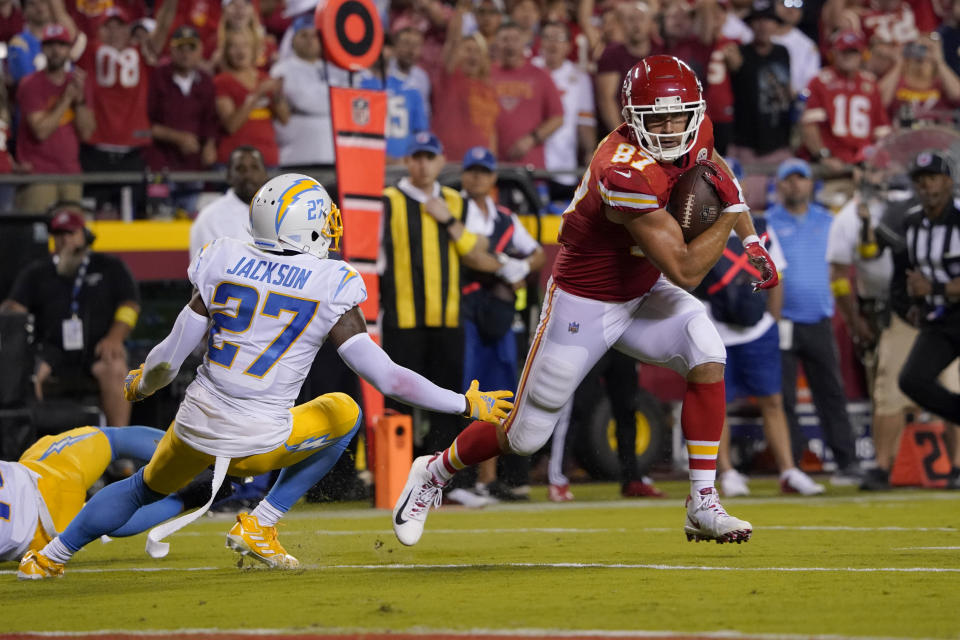 Kansas City Chiefs tight end Travis Kelce (87) runs with the ball past Los Angeles Chargers cornerback J.C. Jackson (27) during the second half of an NFL football game Thursday, Sept. 15, 2022, in Kansas City, Mo. (AP Photo/Ed Zurga)