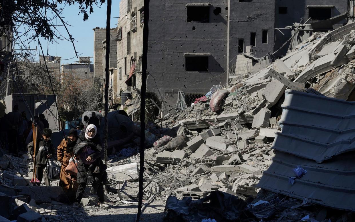 Palestinians inspect the rubble of destroyed buildings after an Israeli airstrike in Nusseirat refugee camp